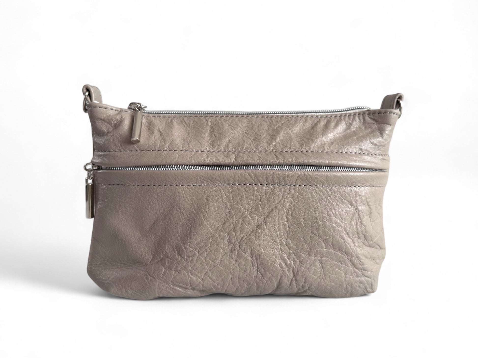 Front view of a hand crafted crossbody bag, which has been made using a soft leather in warm grey. The leather is soft and shows the wrinkles of and texture. The bag is on a white background