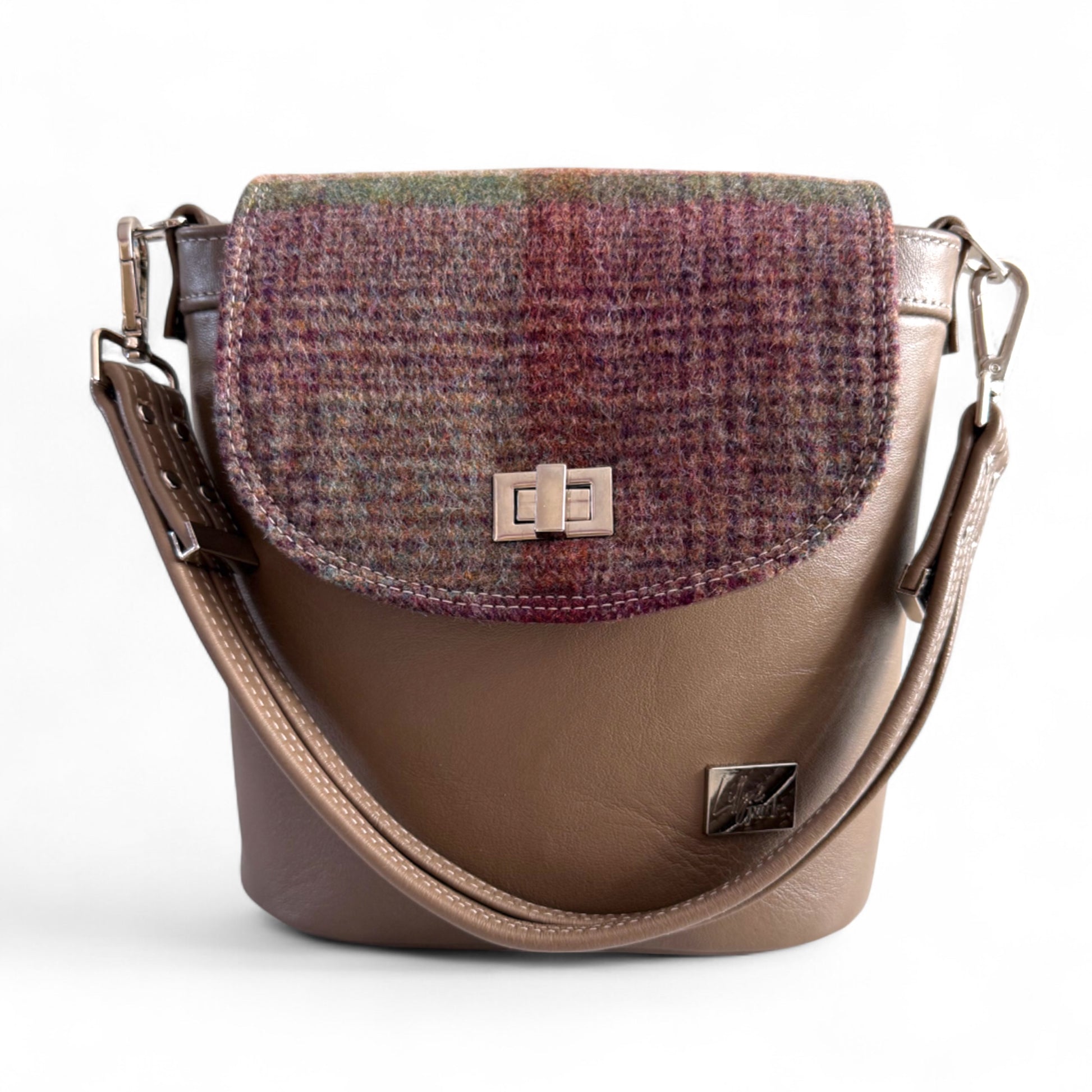 Taupe brown leather handbag with plaid patterned flap on a white background