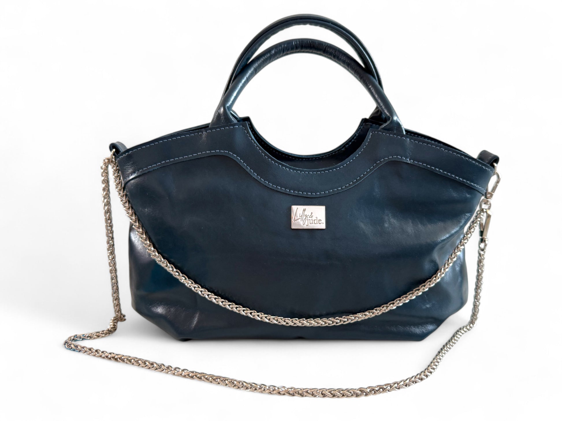 Navy blue rescued leather handbag with a silver chain detail on a white background. Handmade by Lilly & Jude in the UK