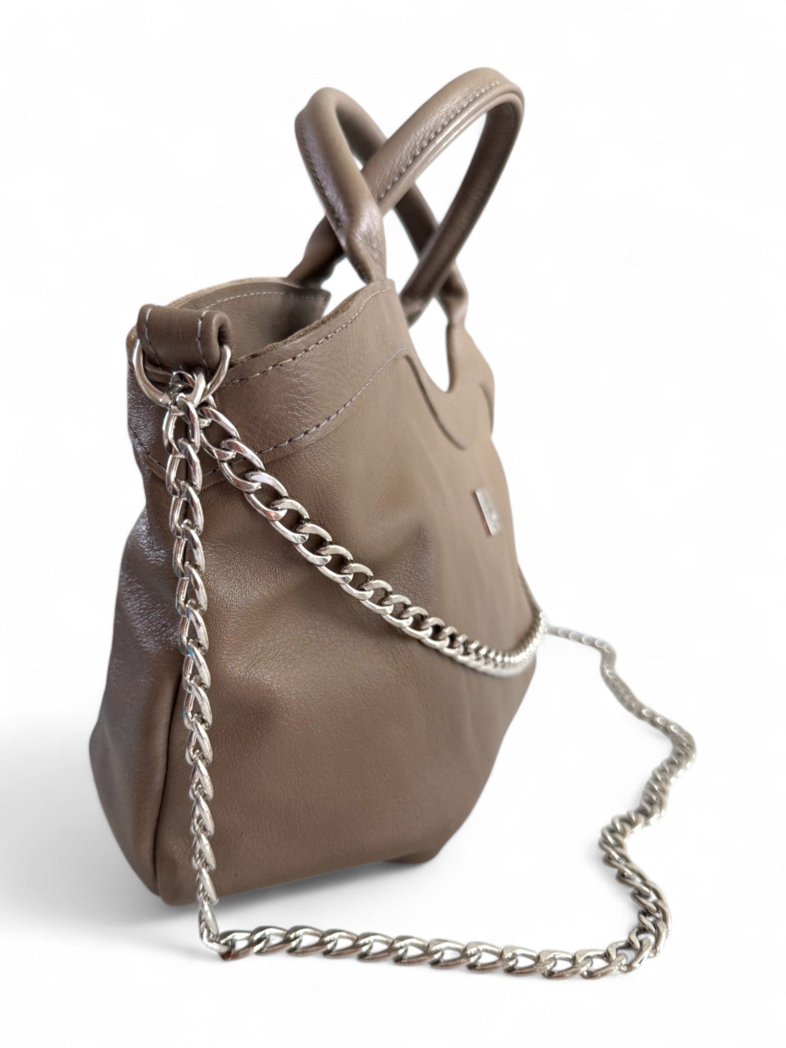 Side view of a grey / beige / taupe leather handbag, showing the silver chain strap and hardware, This one off bag is exclusive to Lilly & Jude