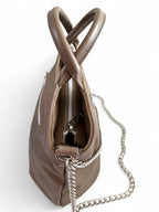 Taupe leather  handbag with a chain detail on a white background. The image is taken from the top corner and shows a glimpse of the silver zipper opening 