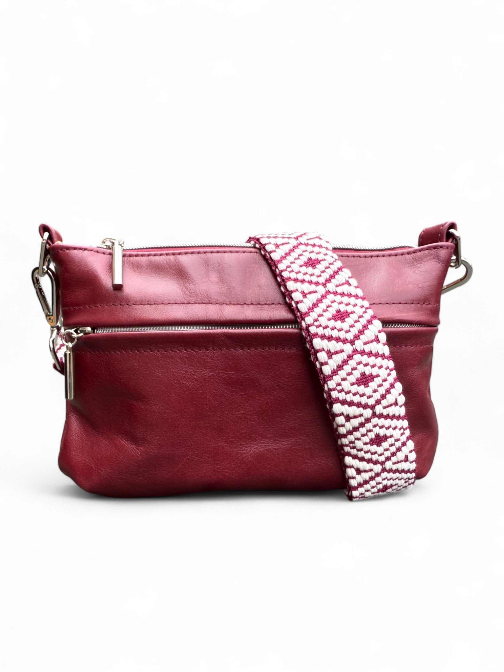 Burgundy Starburn crossbody bag, with patterned, woven strap, sat on a white background. Handcrafted from rescued leather by Lilly & Jude