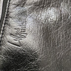 Close-up of a textured black leather surface with a brand logo.