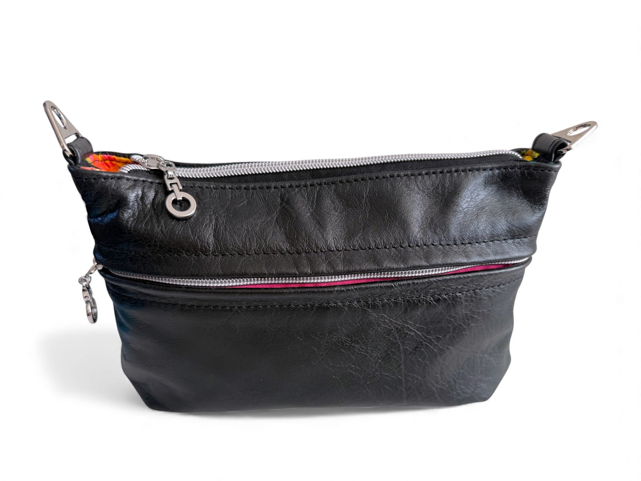 Black leatherhandbag with silver zippers and hardware on a white background