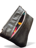 Black leather pouch with colorful interior on a white background