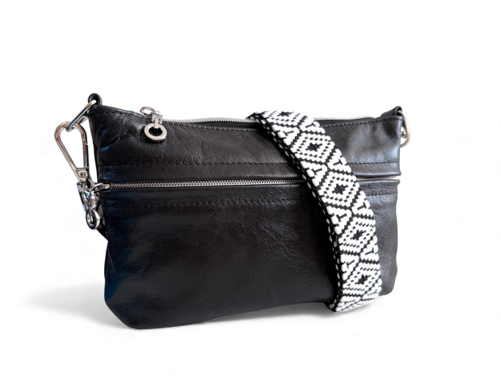 Black leather handbag with a patterned strap on a white background