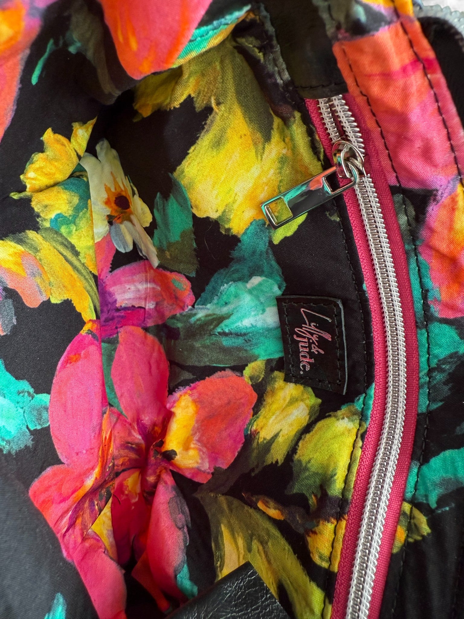 Colorful floral-patterned bag lining with a visible Lilly & Jude logo.