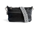 Black leather crossbody bag with a white and black patterned strap on a white background