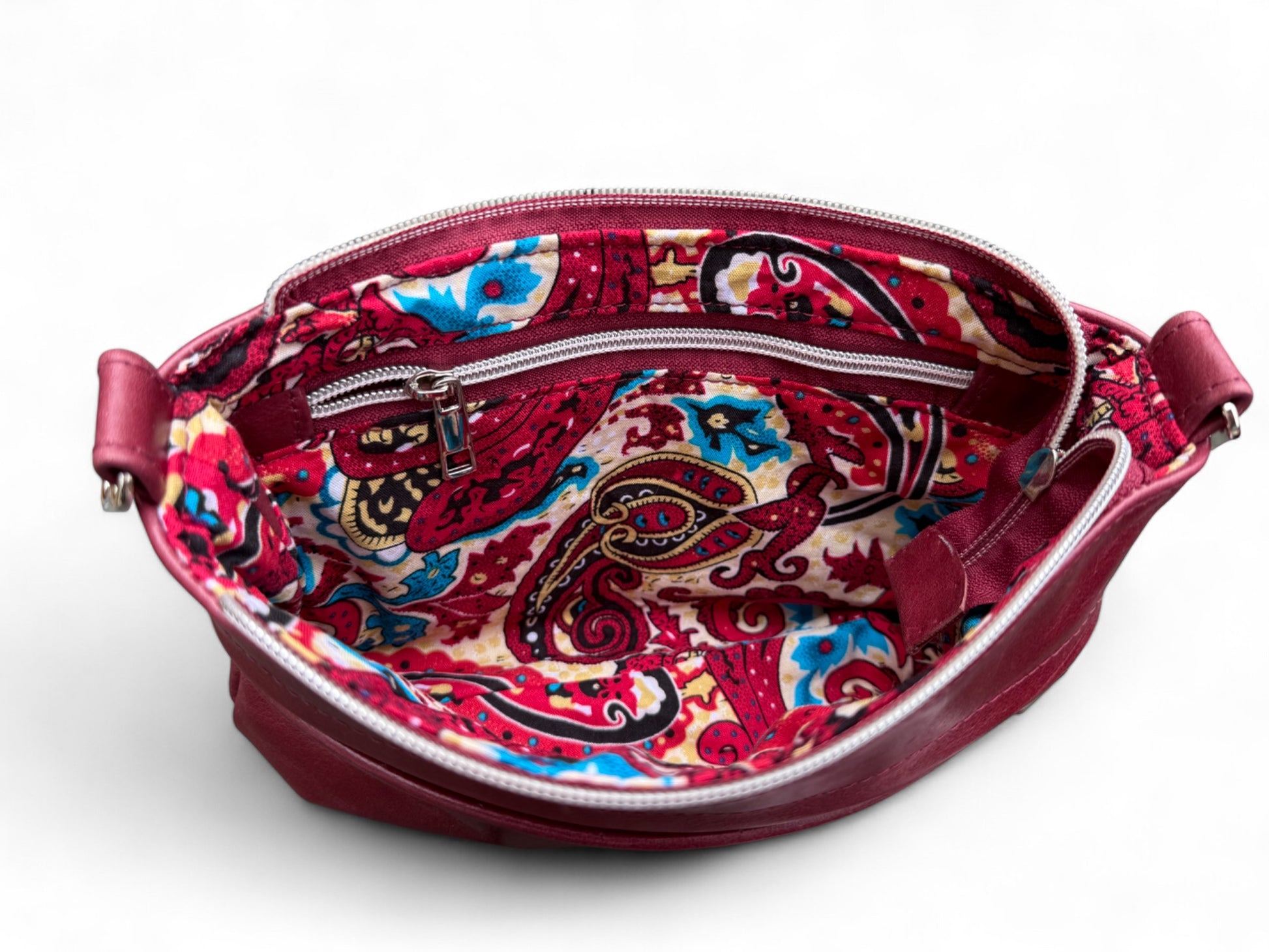 Open view revealing paisley patterned lining and highlighting the interior zipper pocket
