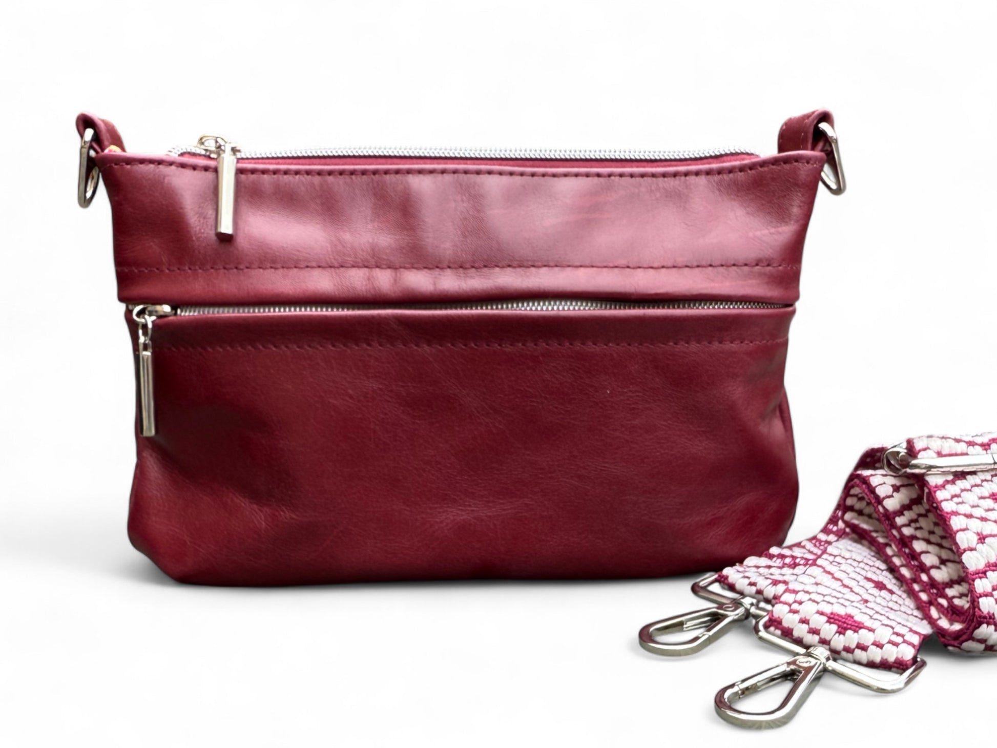 Front view of the handmade burgundy Starburn leather crossbody bag, with woven strap, against a white background
