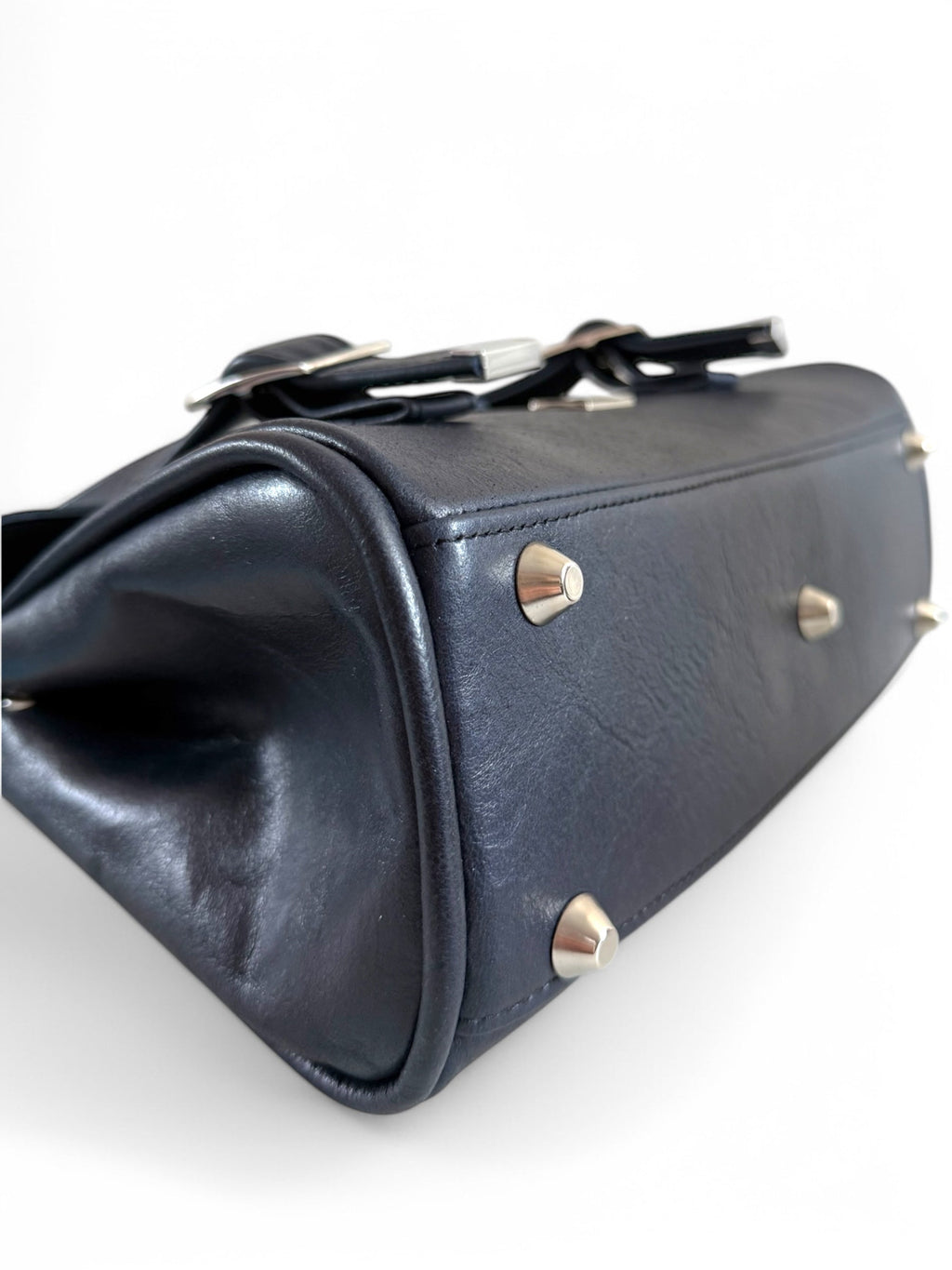 navy blue leather handbag with silver accents on a white background