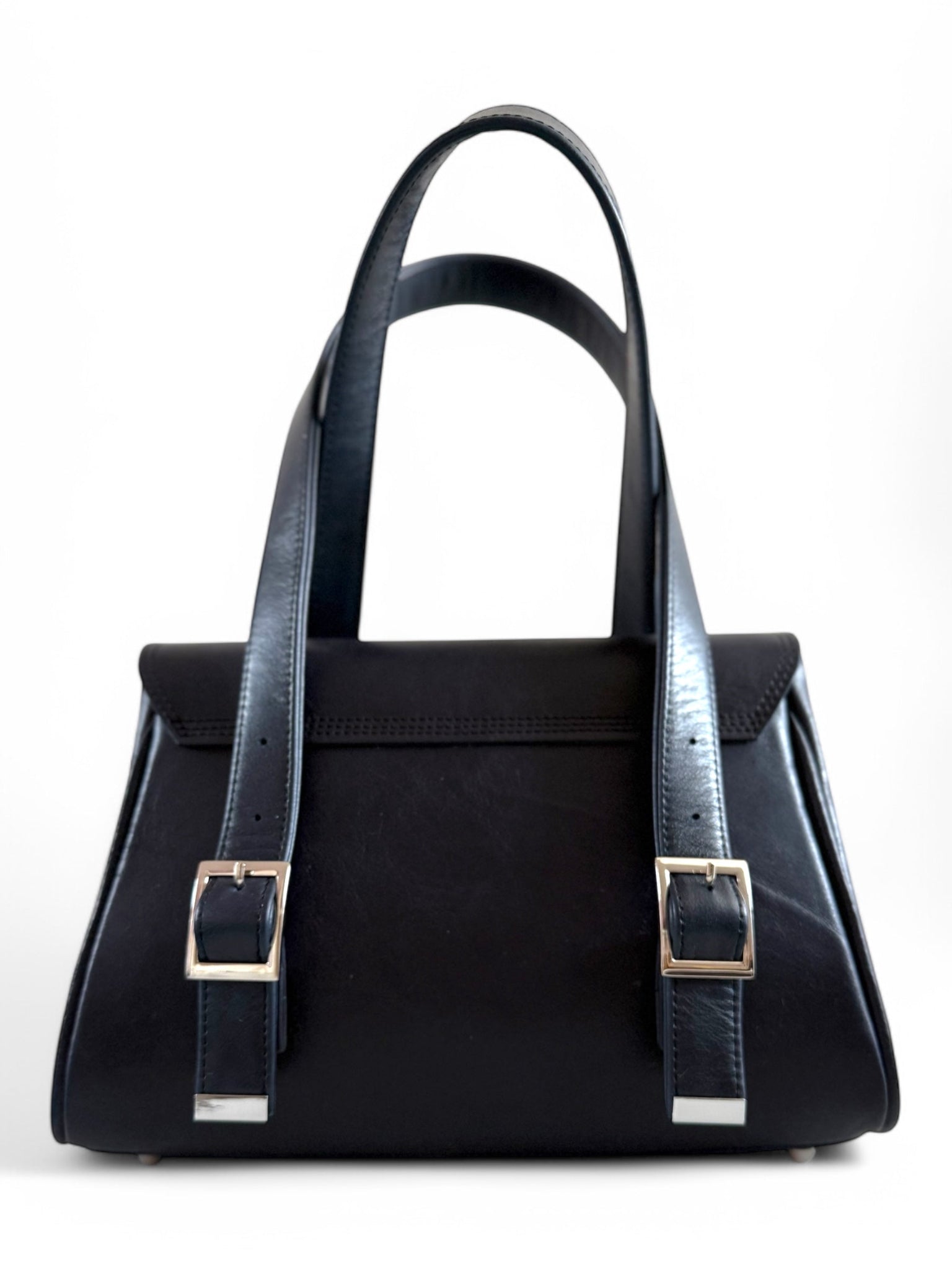 Navy blue leather handbag with blue straps on a white background