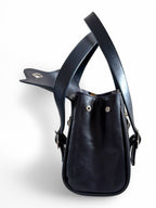 Side view of a navy blue leather bag with straps on a white background