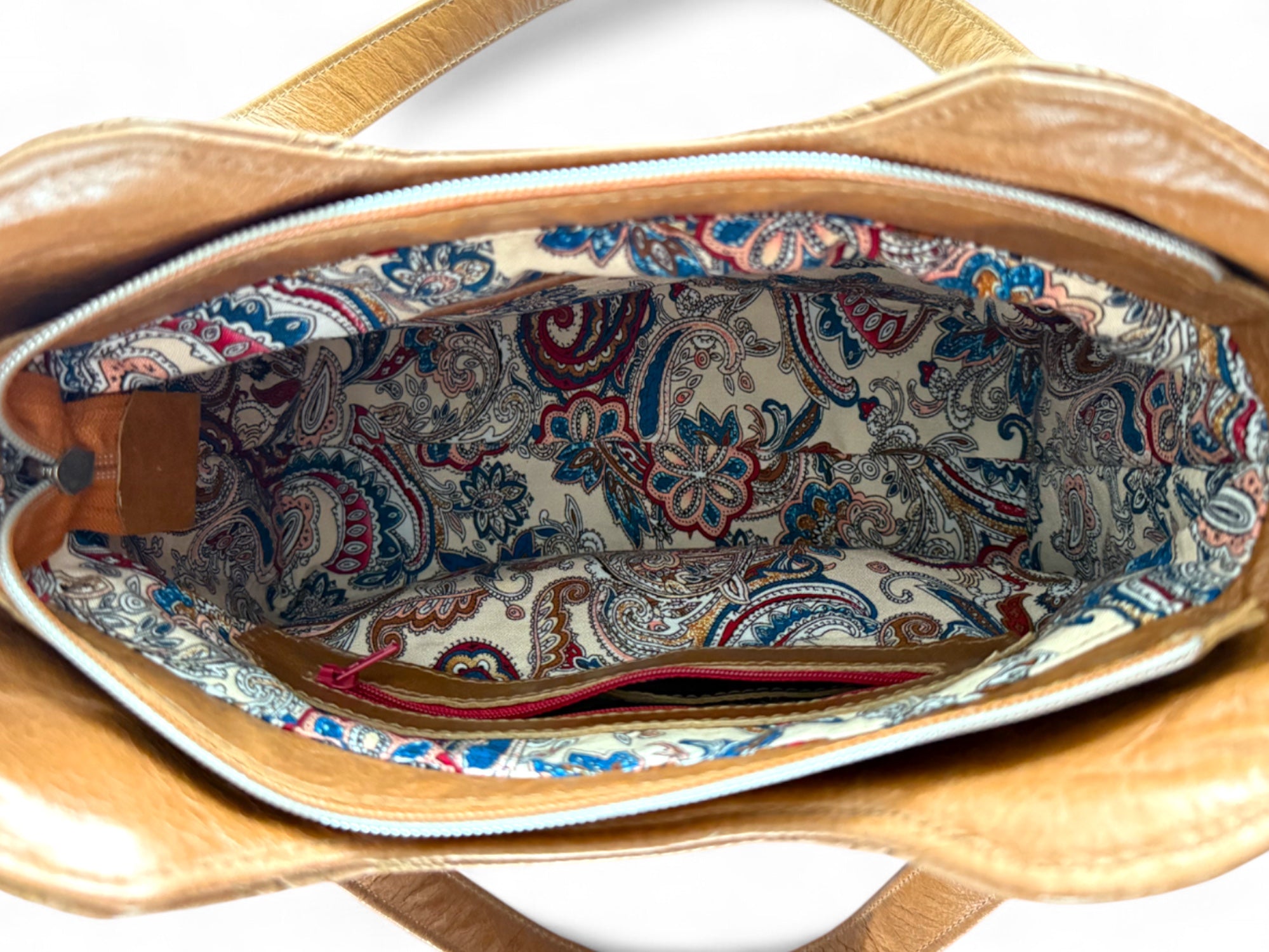 Birds Eye view of the open Alaula shoulder bag, showing the cream, burgundy and blue Paisley patterned interior