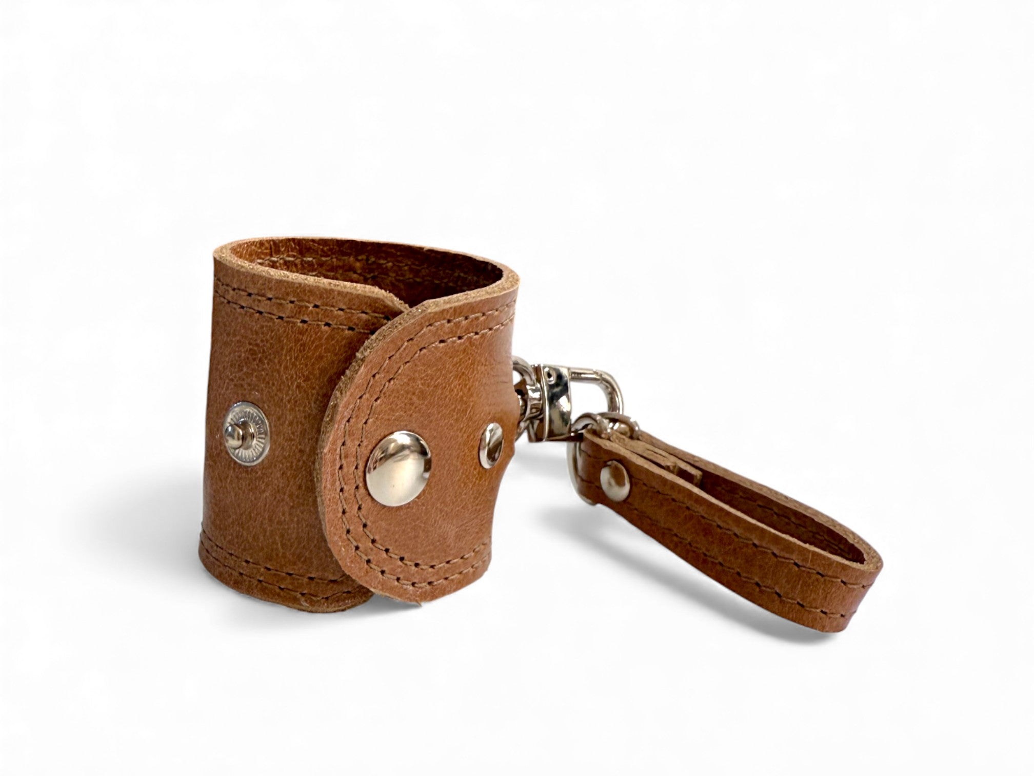 Handcrafted, tan brown leather accessory holder or scarf carrier, with metal accents on a white background. 