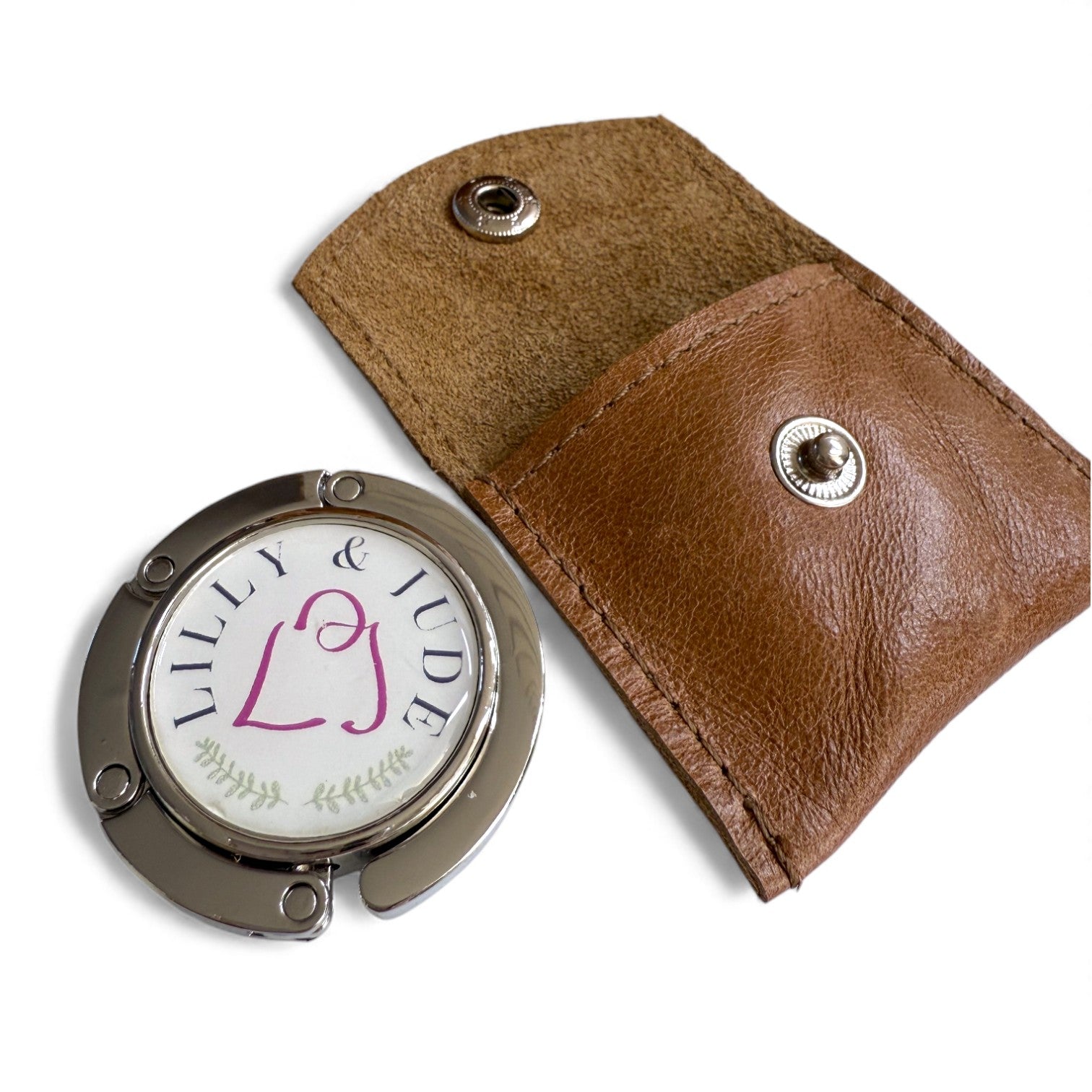 Brown leather case with a round bag hook featuring 'LILLY & JUDE' branding on a white background