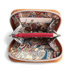 Open tan leather purse with paisley pattern lining, and burgundy zippered coin pouch on a white background