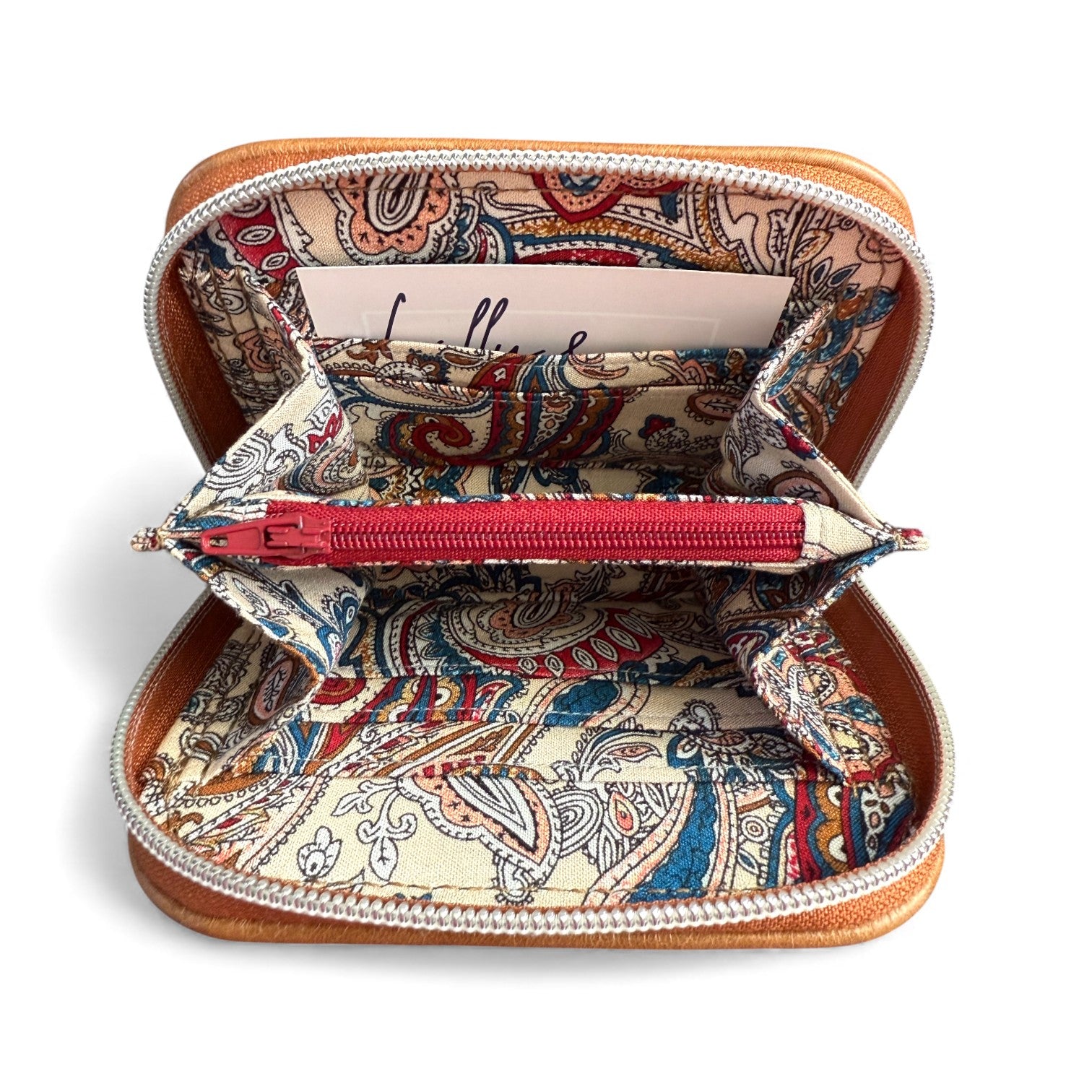 Open tan leather purse with paisley pattern lining, and burgundy zippered coin pouch on a white background