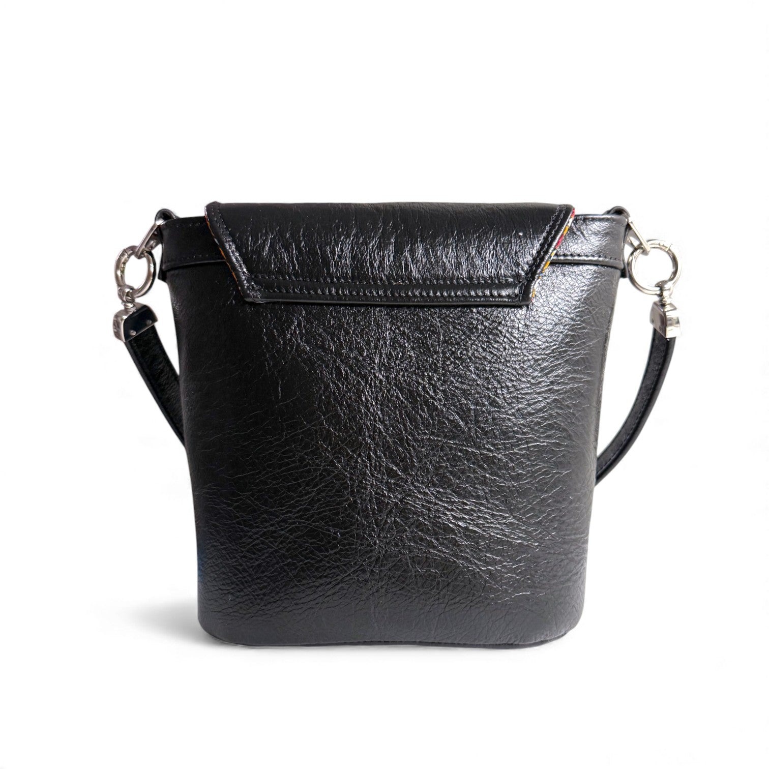 Rear view of the Belle bucket bag, showing the stitching of the flap from the back, against a white background. Sustainable fashion accessories by Lilly & Jude