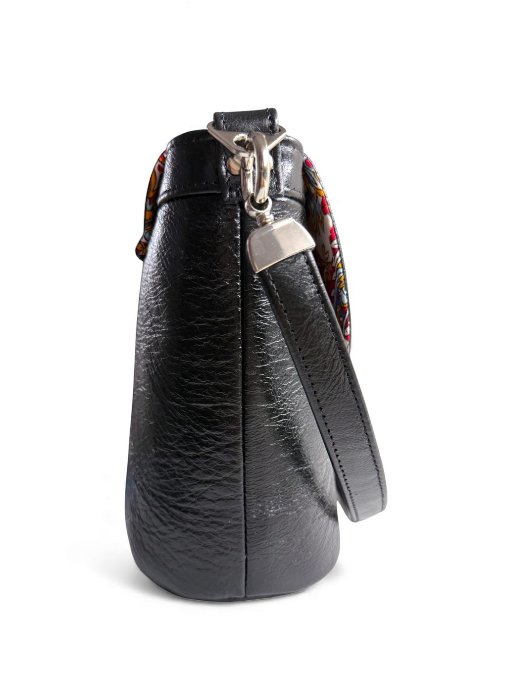 Side view of the Belle handbag, made from black rescued leather. The image highlights the silver hardware, including the strap connector. Exclusive to Lilly & Jude
