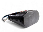 View of the base and side of the Belle Bucket handbag, against a white background. The bag is handcrafted from black rescued leather