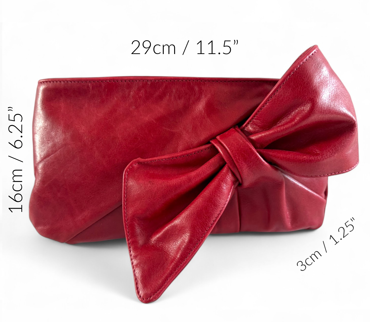 Red clutch bag with a large bow on a white background, showing measurements and dimensions of the bag. The bag is handmade using rescued leather in Shropshire, England