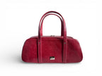 Red leather, baguette style handbag on a white background