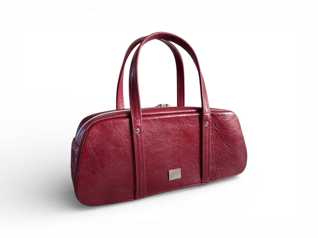Burgundy red leather baguette style handbag on a white background