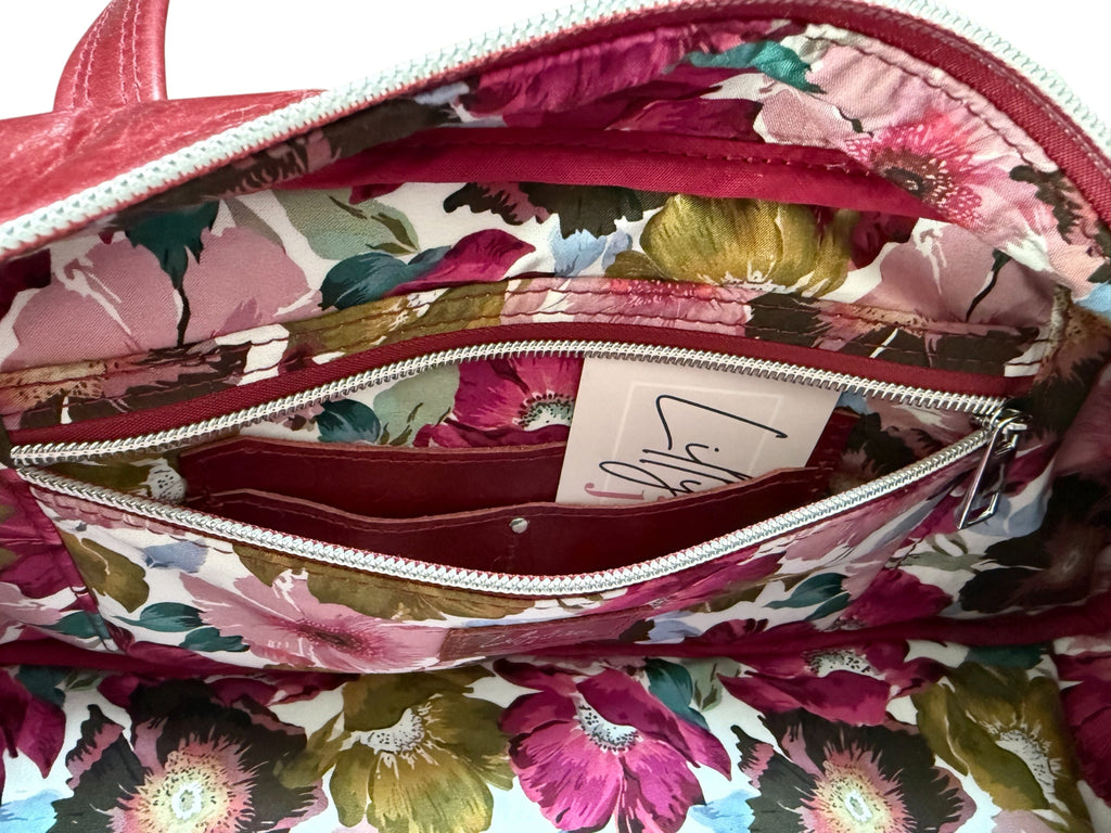 Floral-patterned lining handbag, showing the zip/slip and hidden integrated purse with a visible brand label.