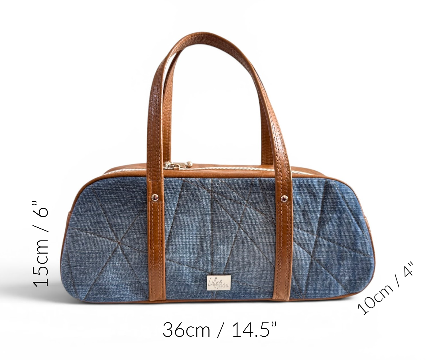 Blue denim handbag with brown leather handles and measurements on a white background
