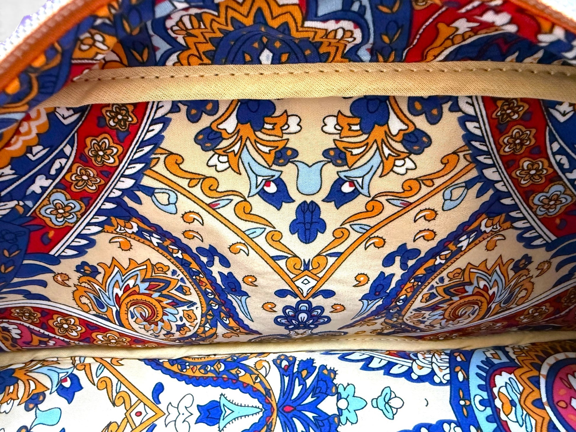 Close-up of a colourful patterned fabric that lines the interior of the Cassie handbag.