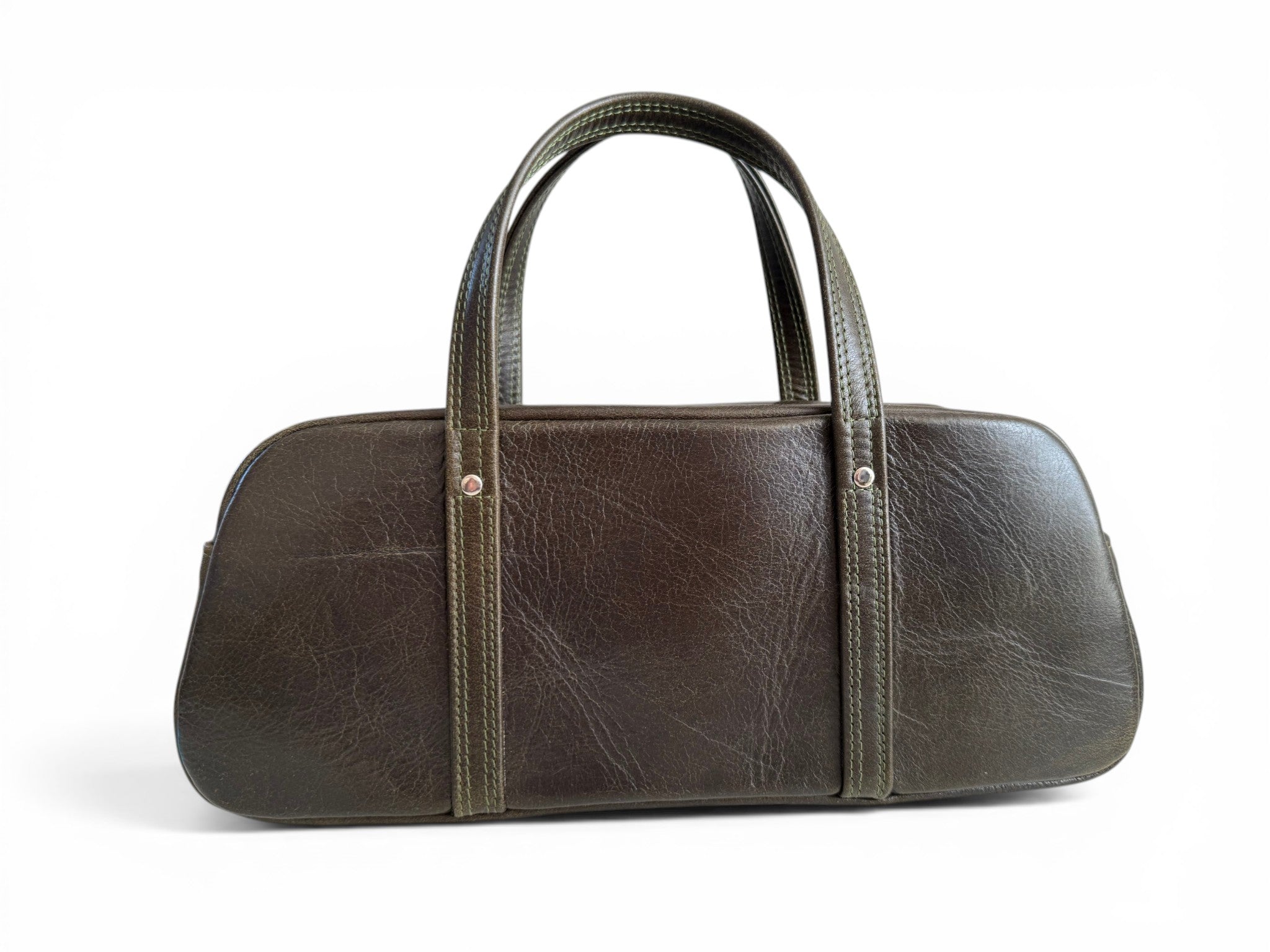 View of the back of the Cassie, a dark green leather handbag on a white background