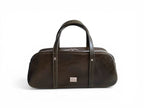 Dark green leather bowling style bag with silver hardware, against a white background