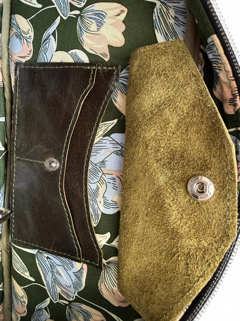 Close up of the interior of the Cassie bowling bag, showing the green floral lining and a Lilly & Jude integrated purse 