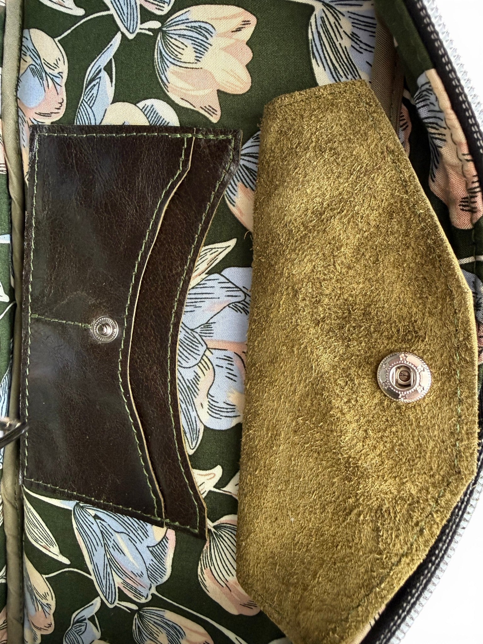 Close up of the interior of the Cassie bowling bag, showing the green floral lining and a Lilly & Jude integrated purse 