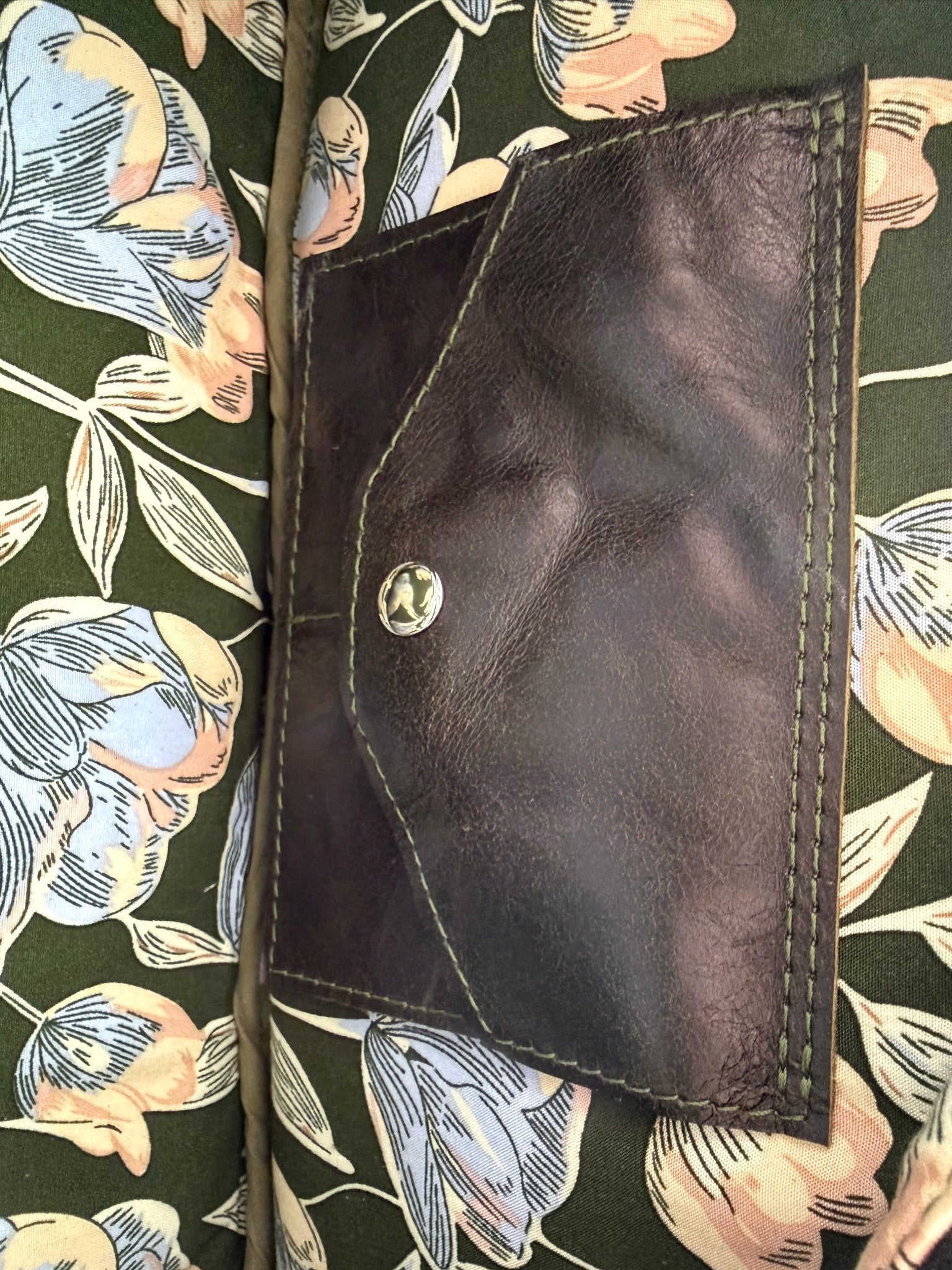 Inside view of the Cassie baguette bag, showing the floral lining fabric and the signature Lilly & Jude integrated purse