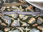 Closeup of the slip/zip pocket and green floral lining fabric inside the dark green leather handbag