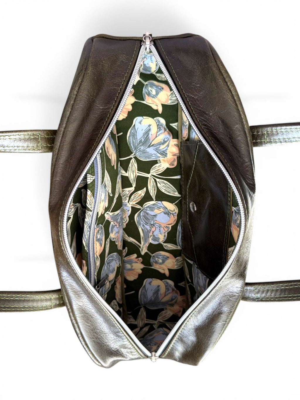 Birds eye view of the top of the Cassie baguette bowling bag, with the zipper open, to show the lining fabric inside