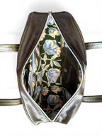 Birds eye view of the top of the Cassie baguette bowling bag, with the zipper open, to show the lining fabric inside
