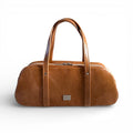 Tan brown leather, bowling style bag, against a white background. Handcarfted in the UK
