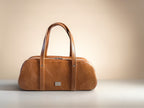 Brown leather Baguette handbag on a beige background