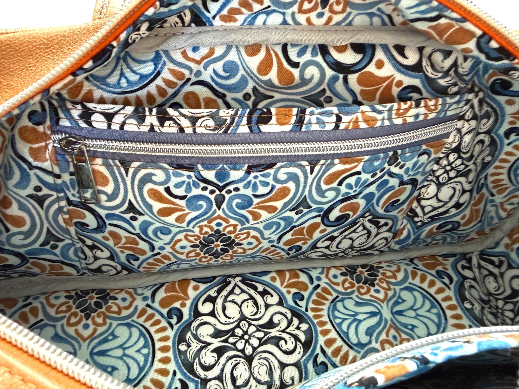 Patterned bag lining with slip and zip pockets on a matching fabric background