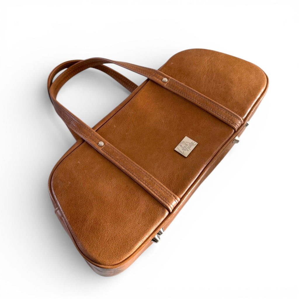 Brown leather bag with a visible Lilly & Jude brand logo on a white background