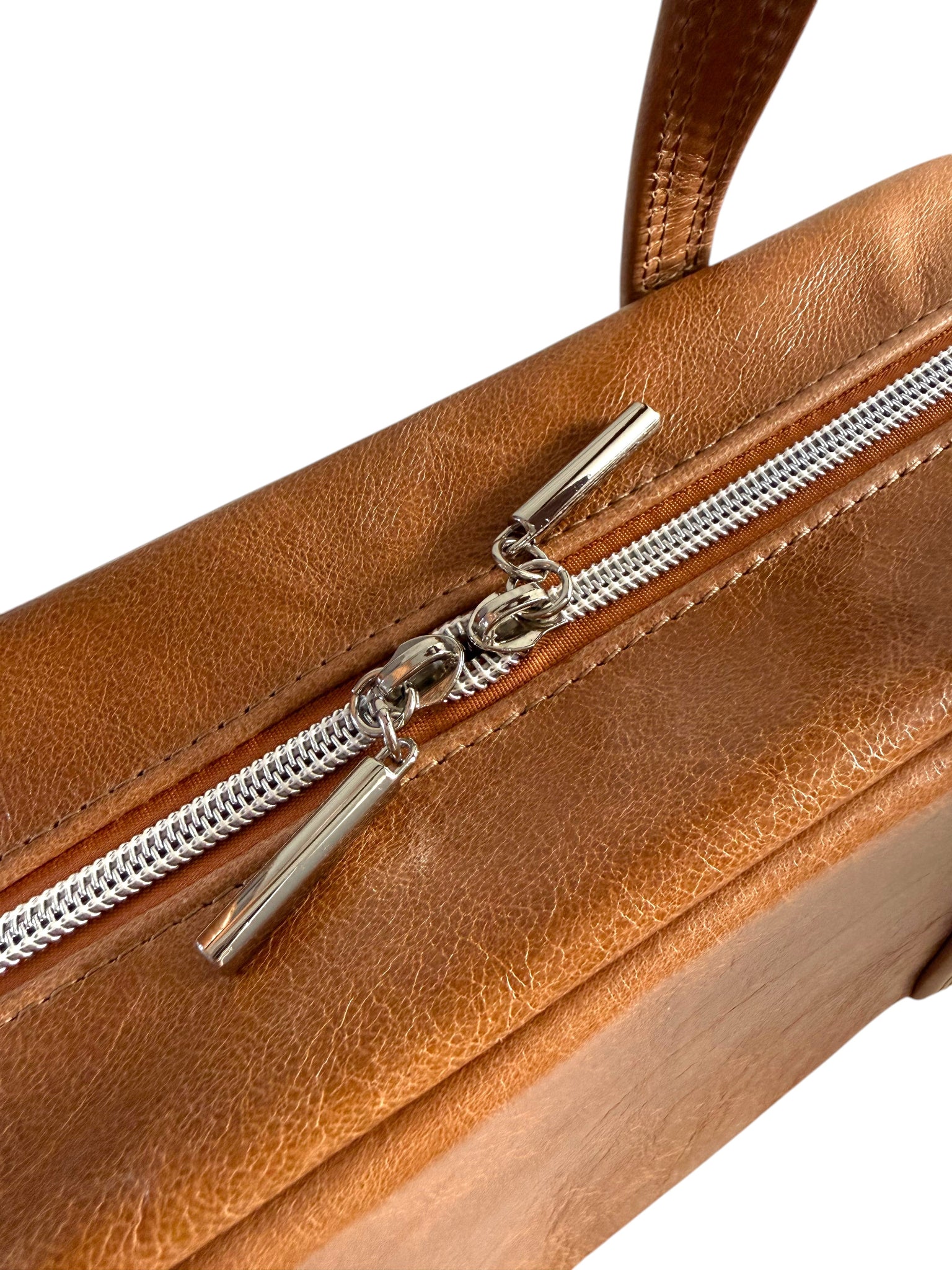 Brown leather handbag with a silver zipper and pulls on a white background