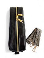 Birds Eye view of the Catalina crossbody bag. A black leather bag with gold zipper and patterned strap on a white background