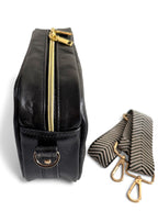 Top view of the Catalina crossbody bag. Handmade from black, rescued leather bag with gold zipper and hardware with a matching strap on a white background