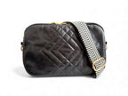 Black quilted leather handbag with a patterned strap on a white background