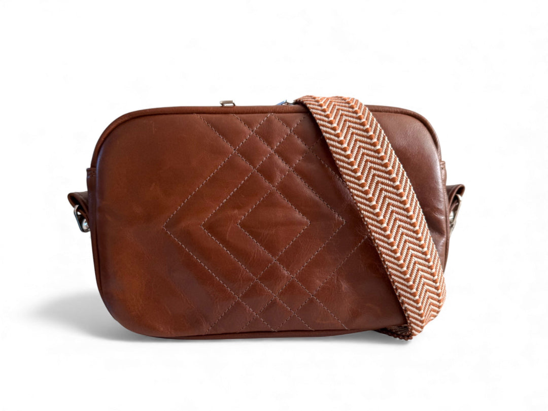 Brown quilted leather crossbody bag with a herringbone pattern strap on a white background