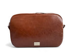 View of the back of the Catalina crossbody bag. A brown leather bag with a visible Lilly & Jude logo on a white background