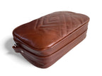 Brown leather case with a diamond pattern quilting on the front panel, on a white background